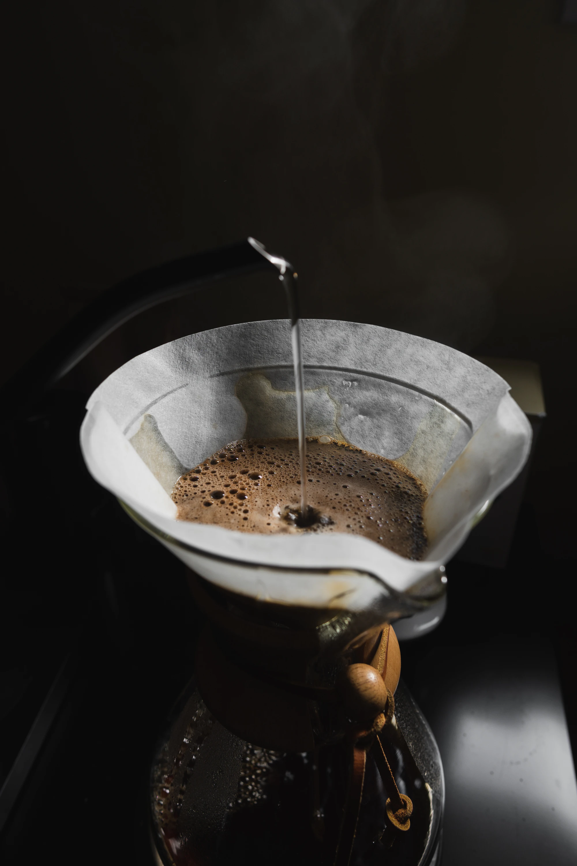 Coffee being brewed through a paper filter in the dark