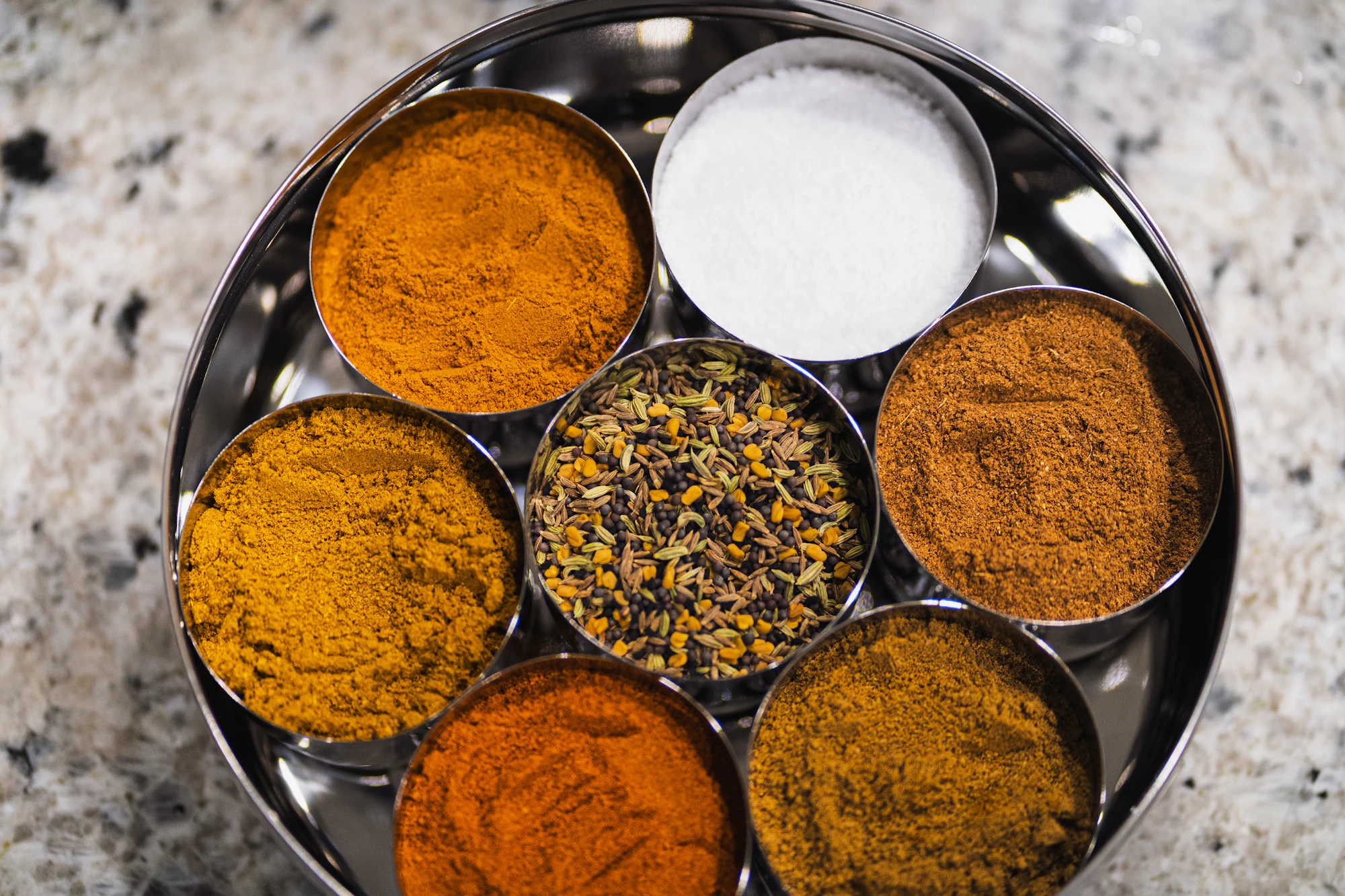 Freshly ground spices in steel bowls