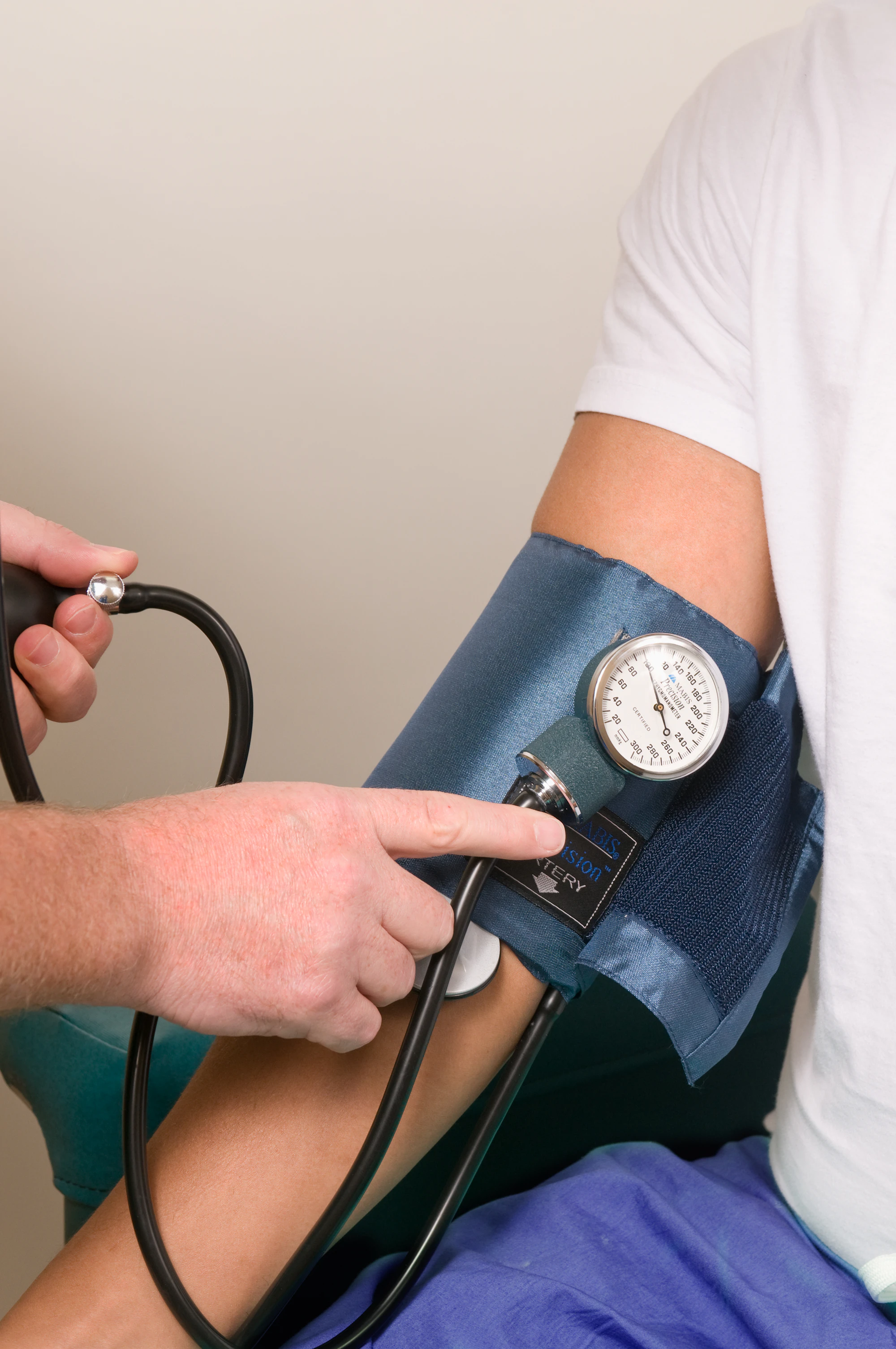 A doctor checking a patient's blood pressure with a cuff and gauge