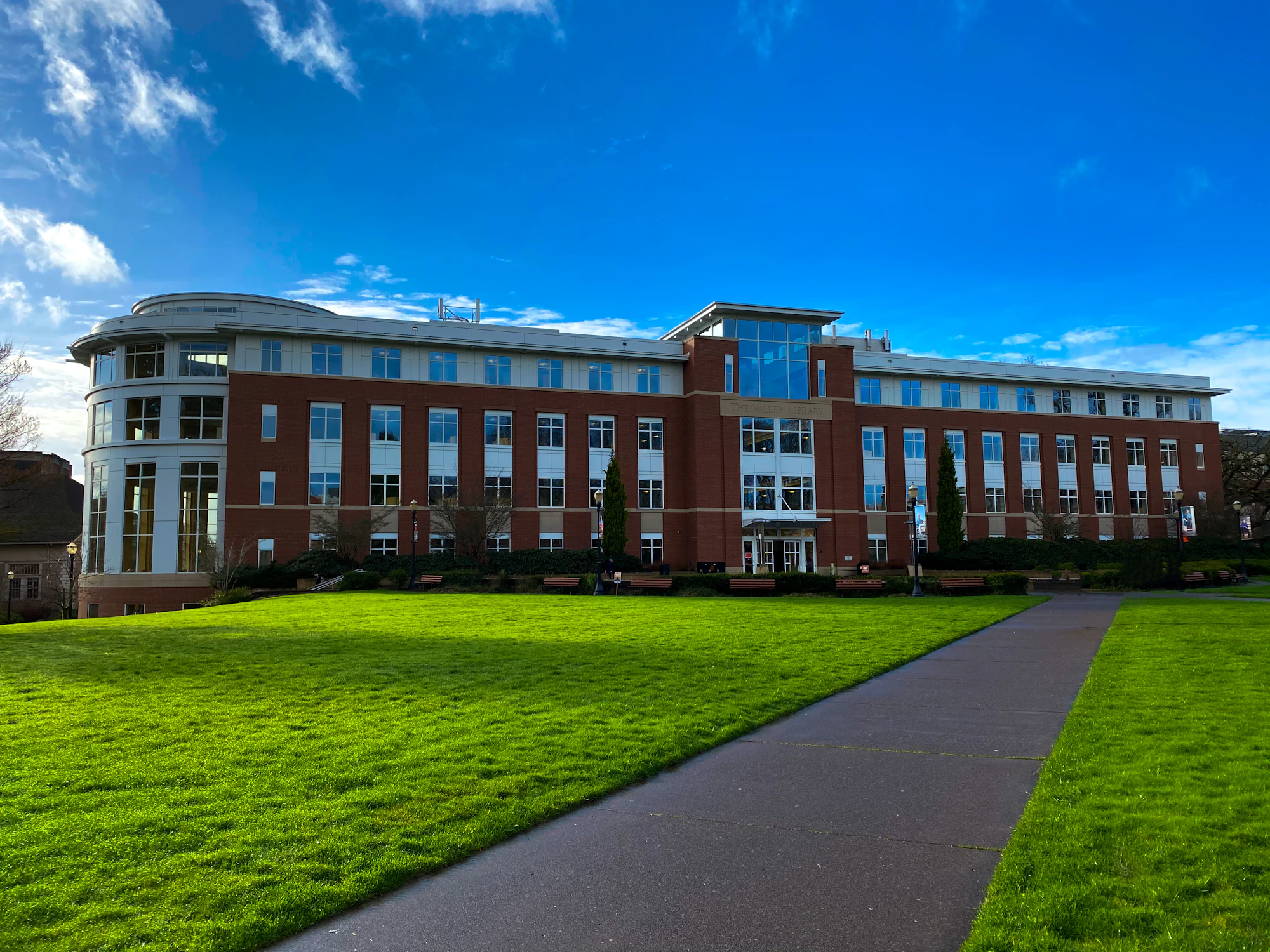 A path across green lawns to a college building