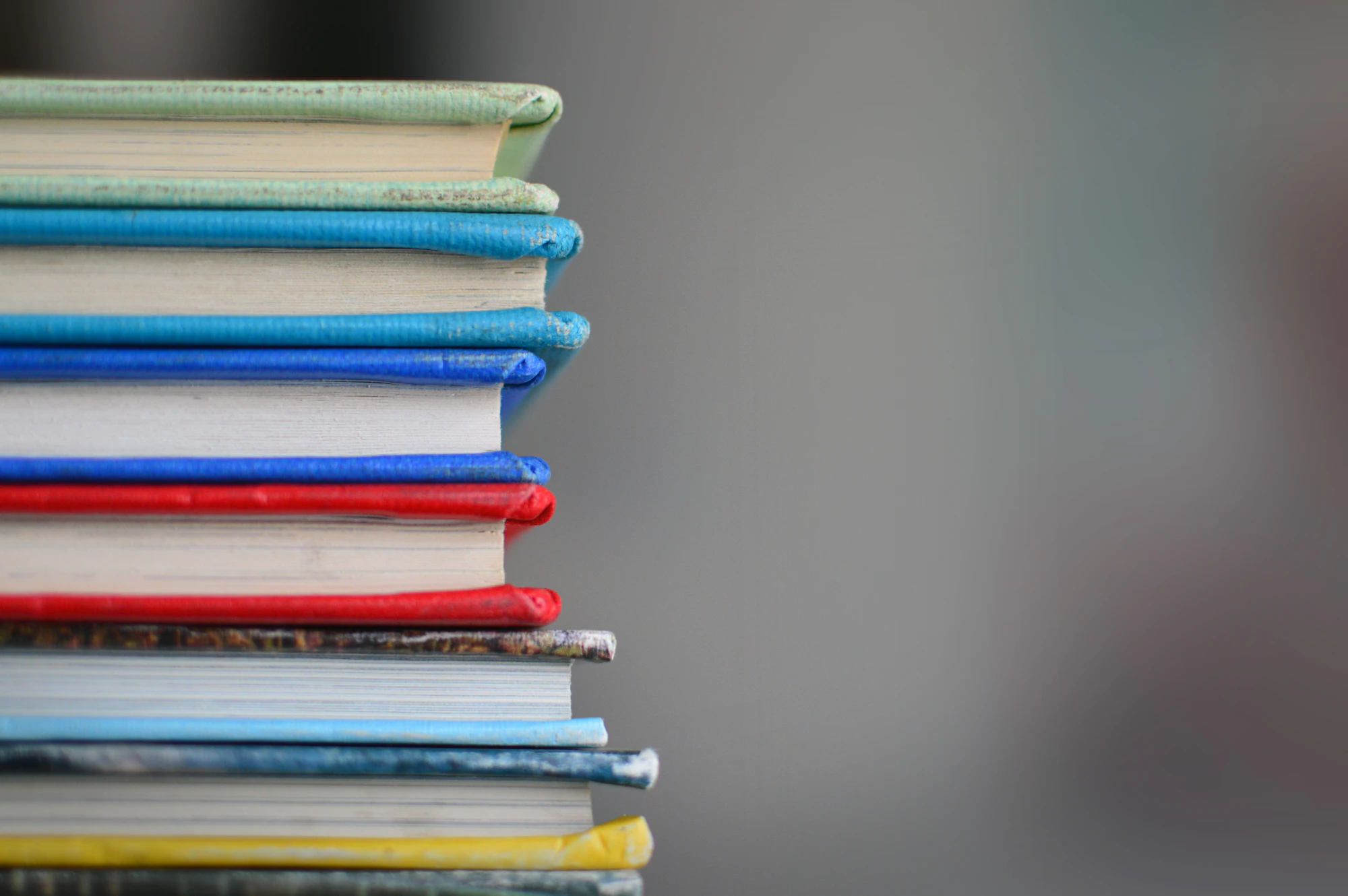A stack of hardback books with coloured spines