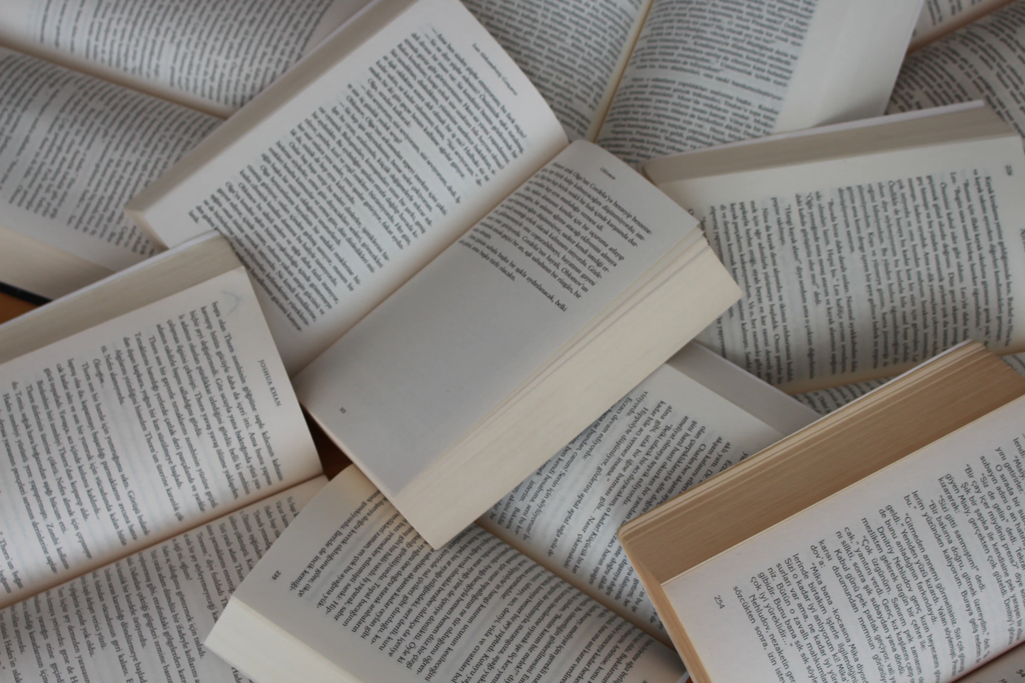 A pile of open paperback books