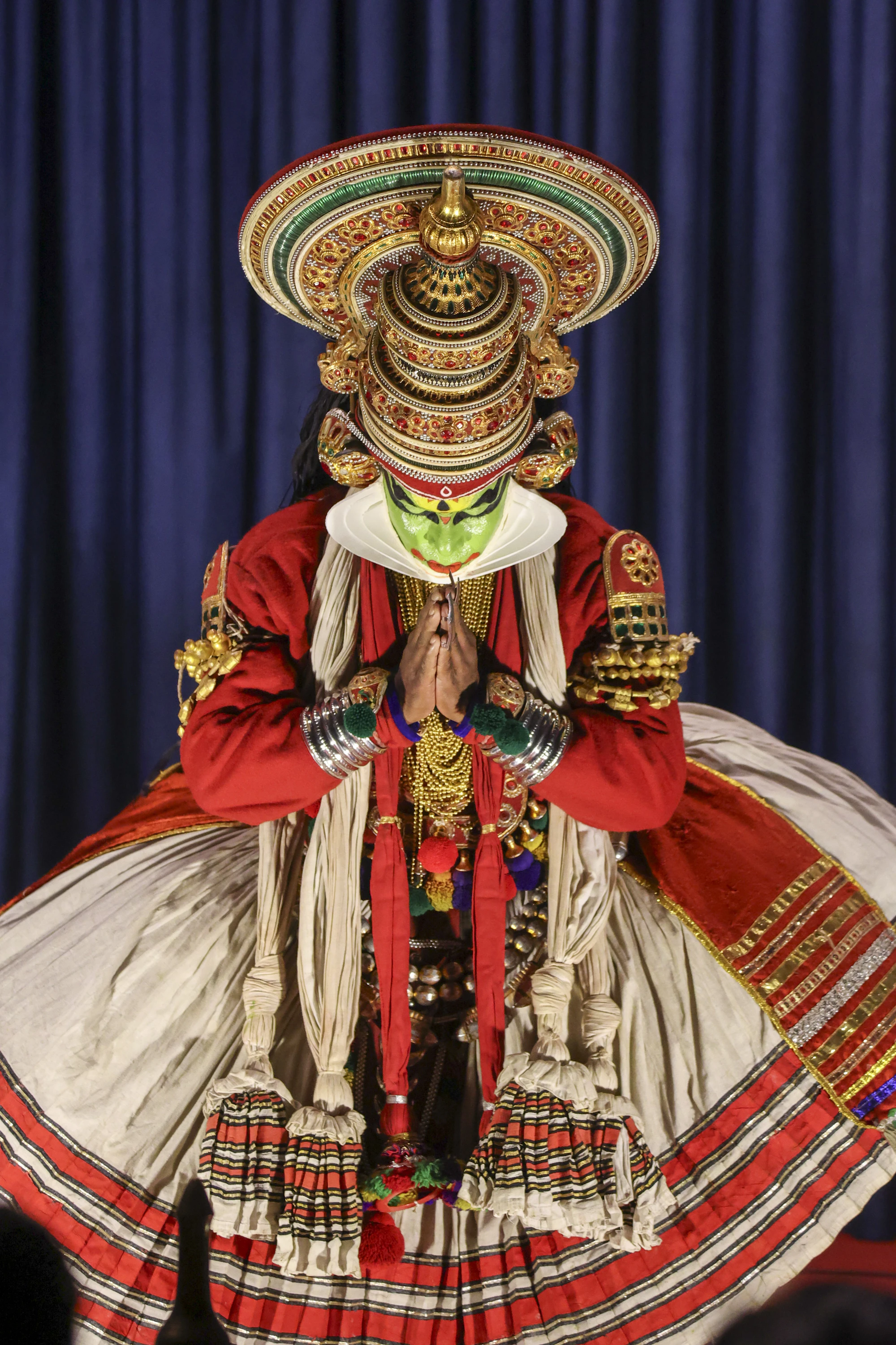 A Kathakali performer in full costume and green face make-up on stage