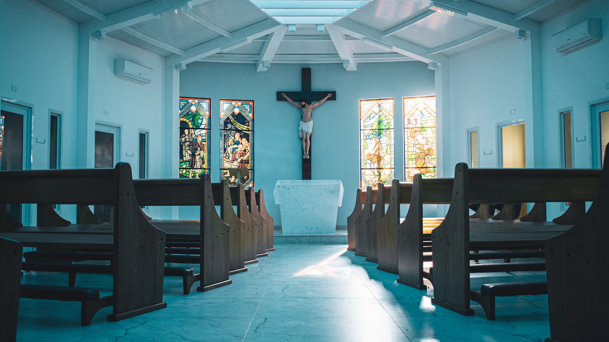 Wooden pews in a small, bright chapel