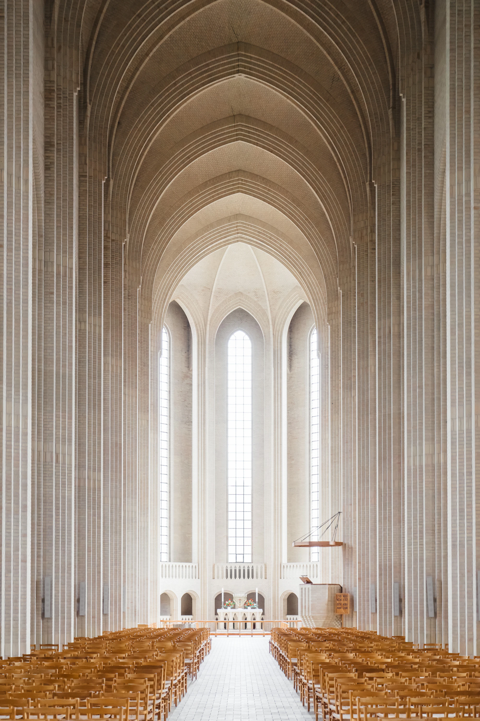 A tall white church interior with rows of chairs