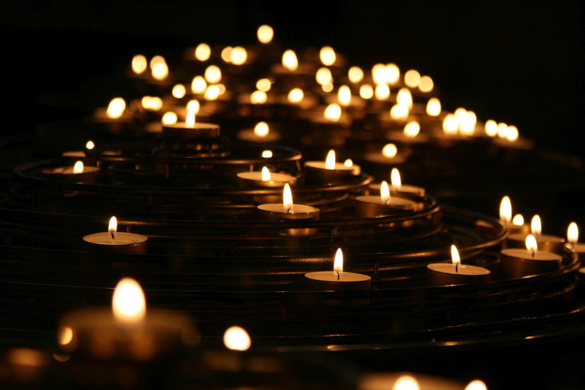Many lit candles in the dark