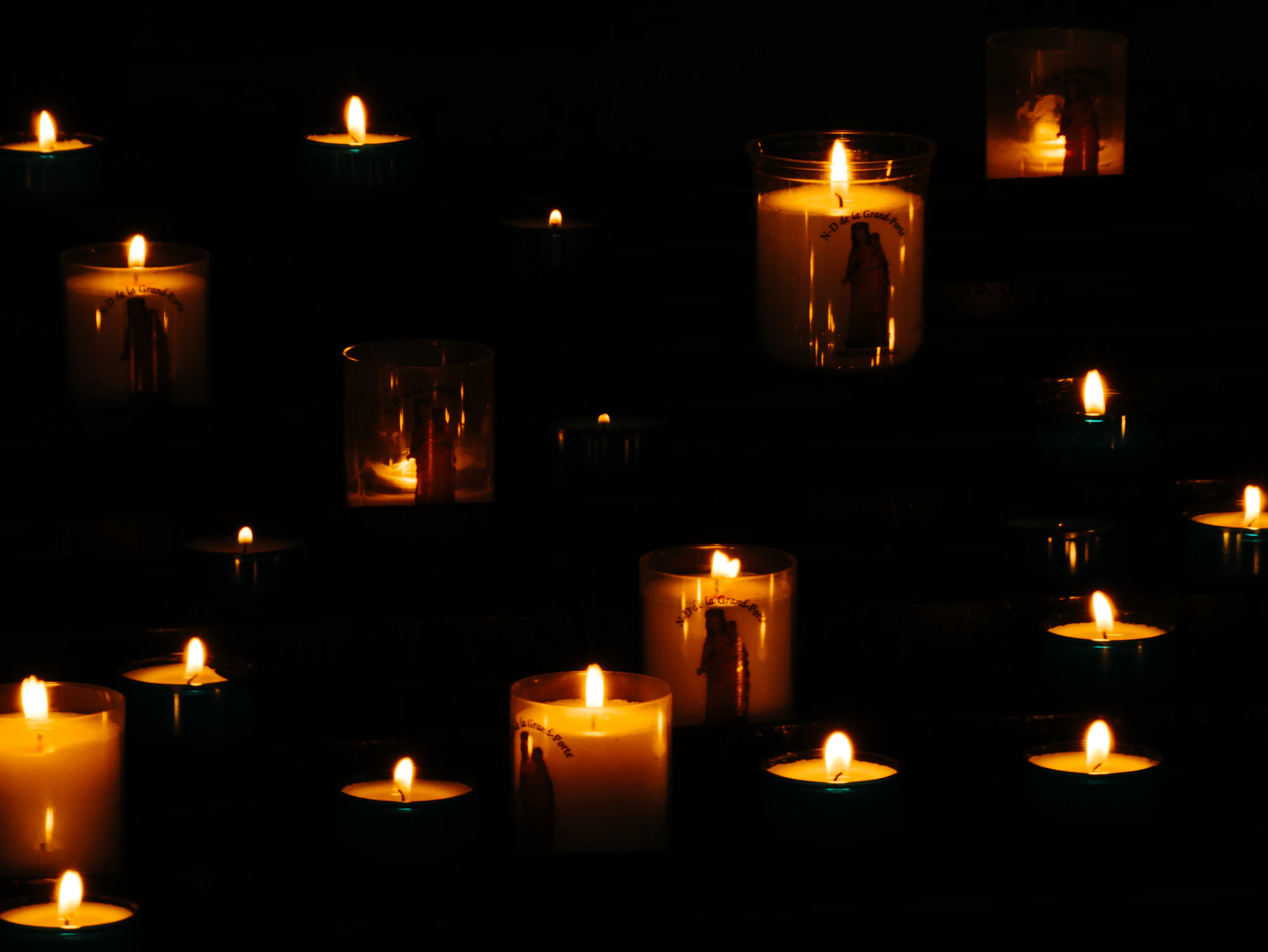 Candles in glass holders glowing in the dark