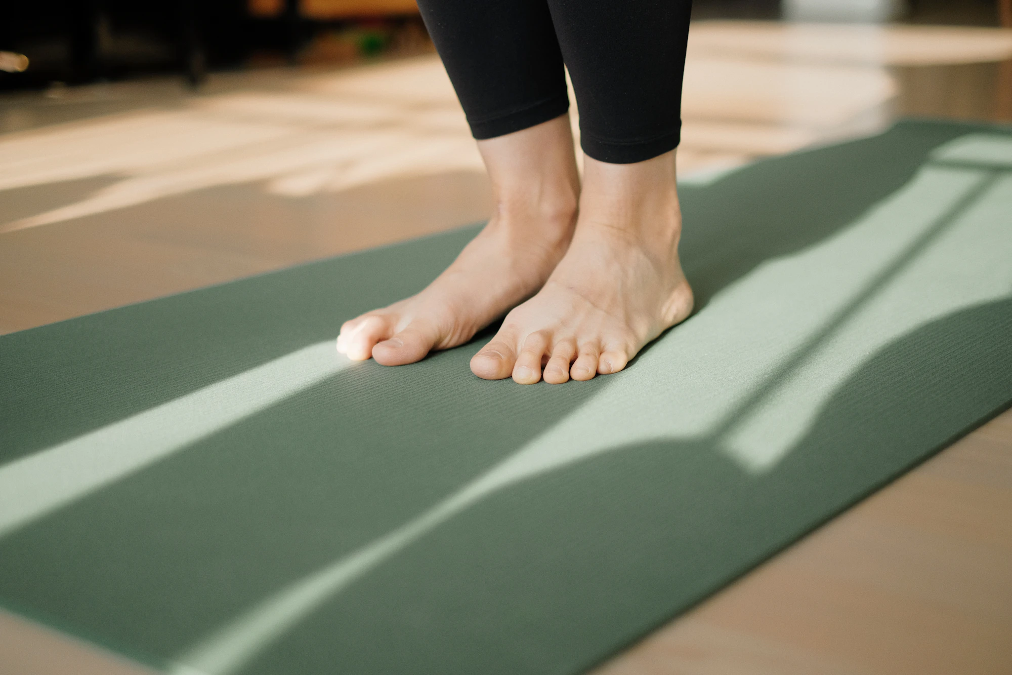 Bare feet standing on a green yoga mat