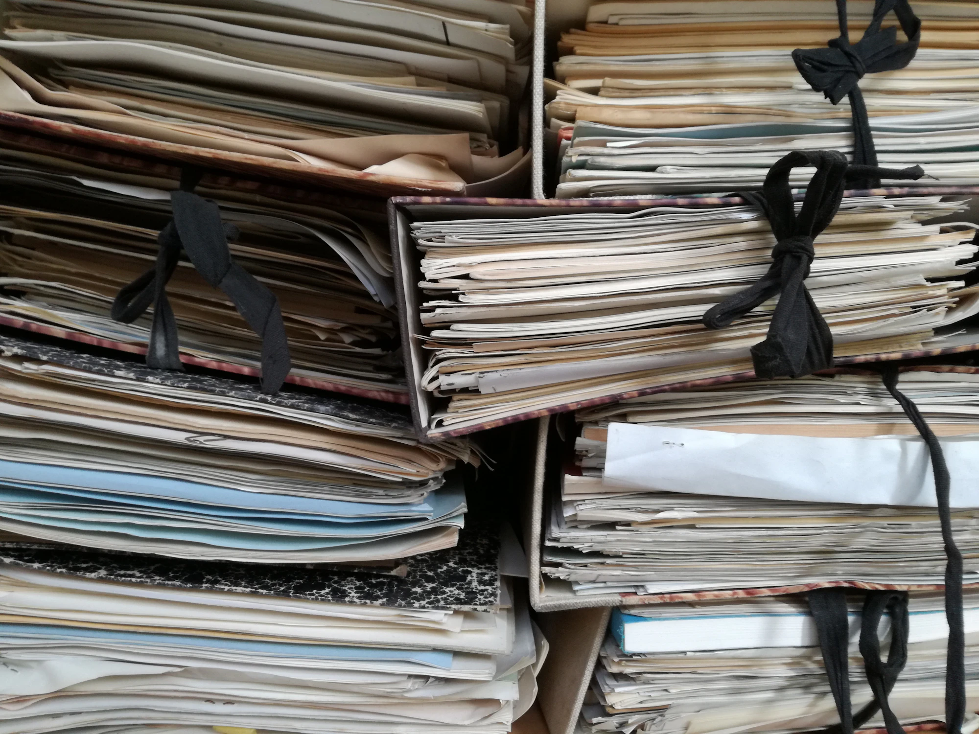 Stacks of old paper files tied with string