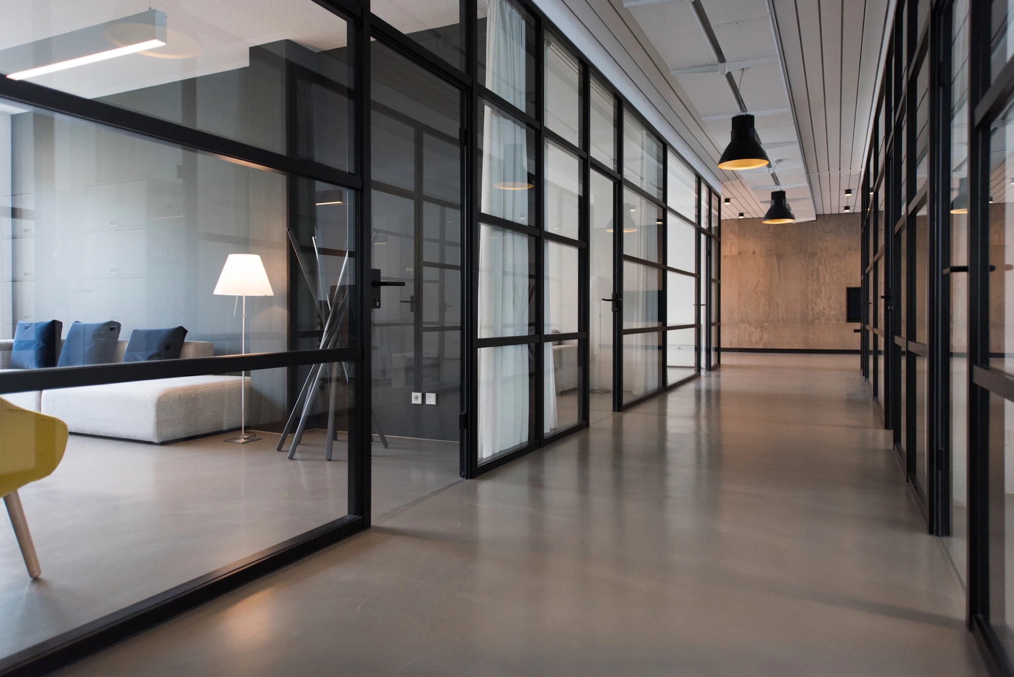 Office corridor between glass-panelled rooms