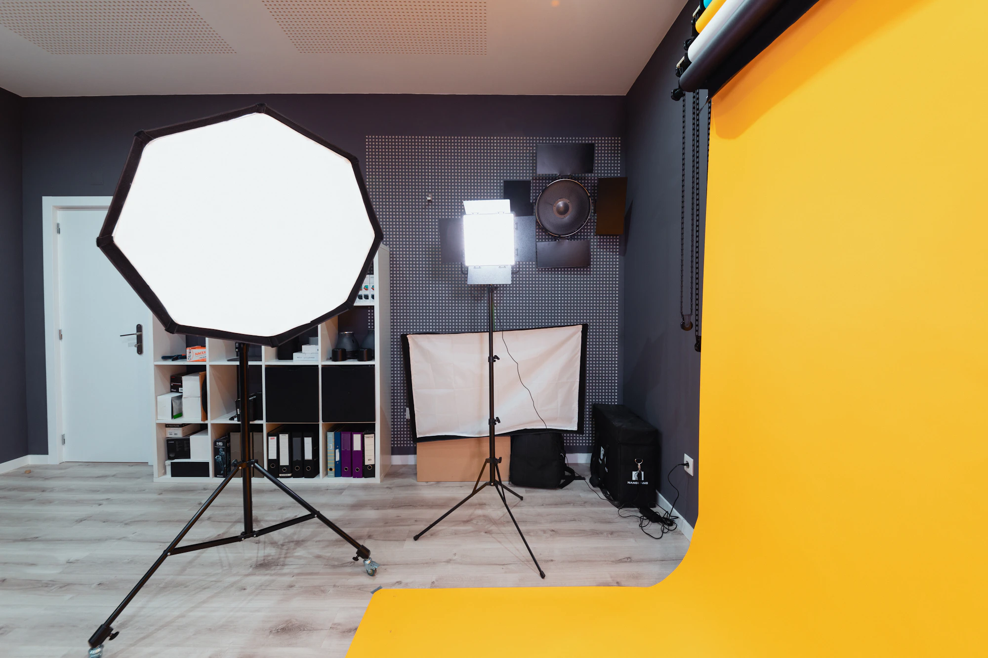 Photo studio with an octagonal softbox, LED light and a yellow wall