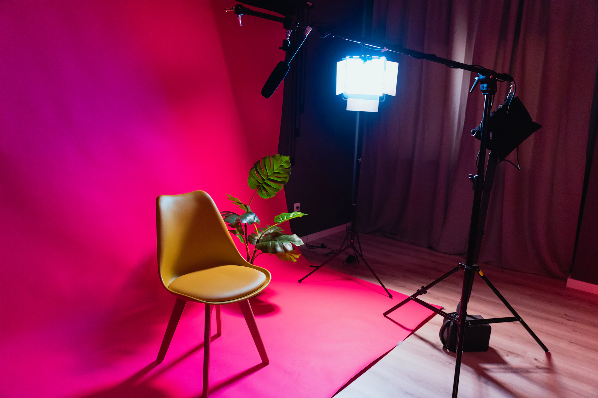 Chair in front of a pink backdrop with an LED panel on a boom