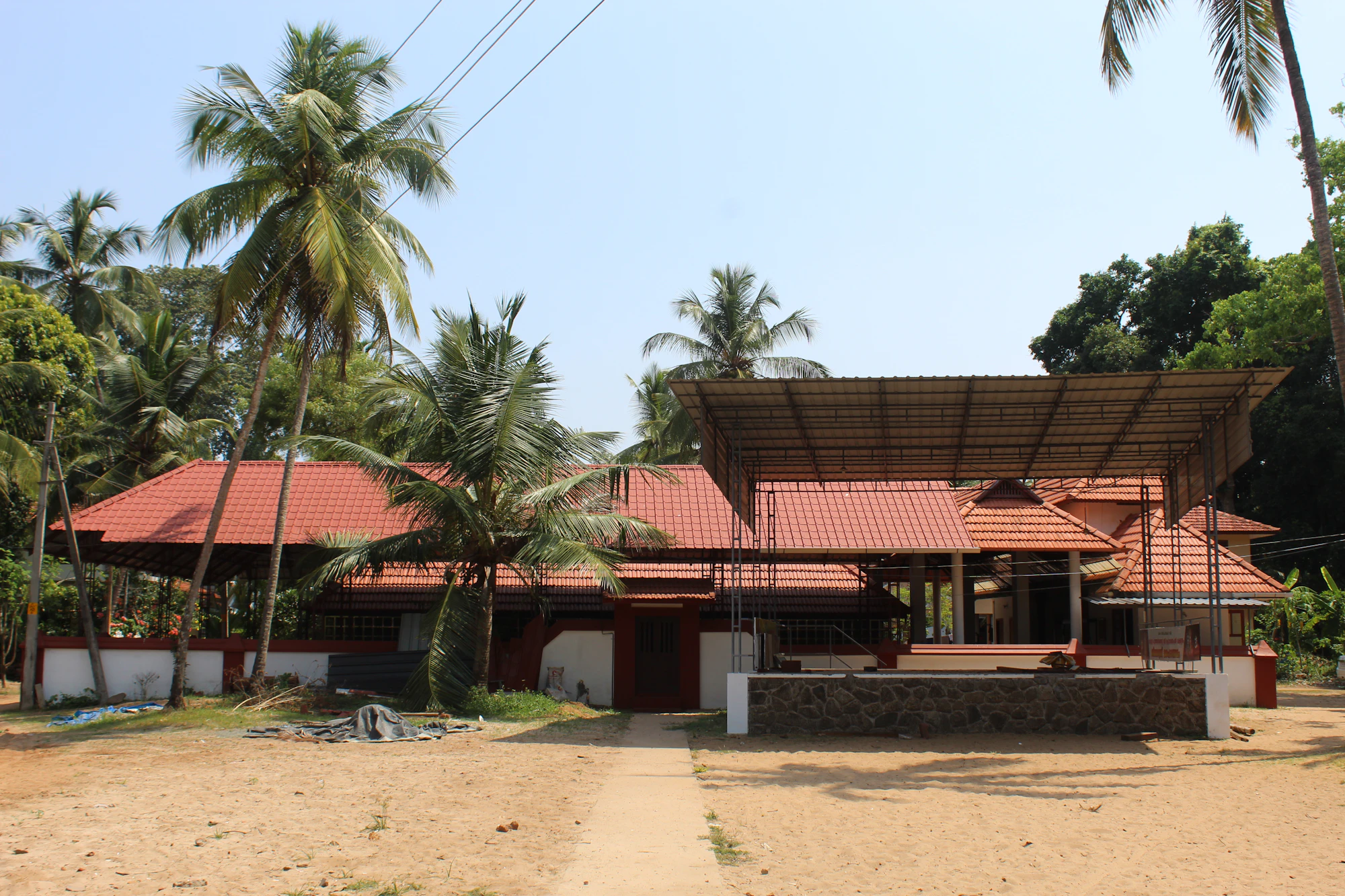Building with red tiled roofs among coconut palms