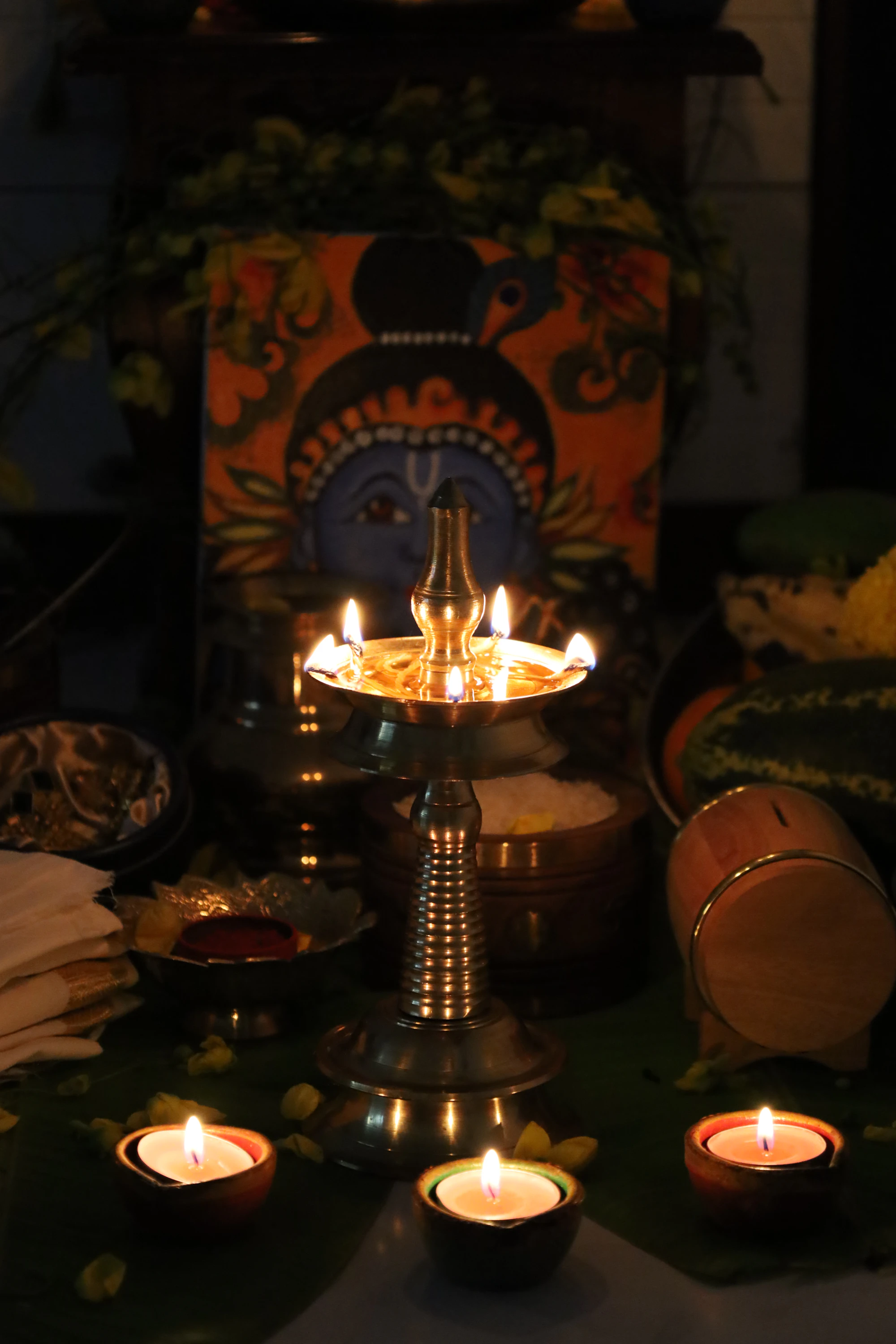 Brass lamp and small oil lamps lit on a table at night